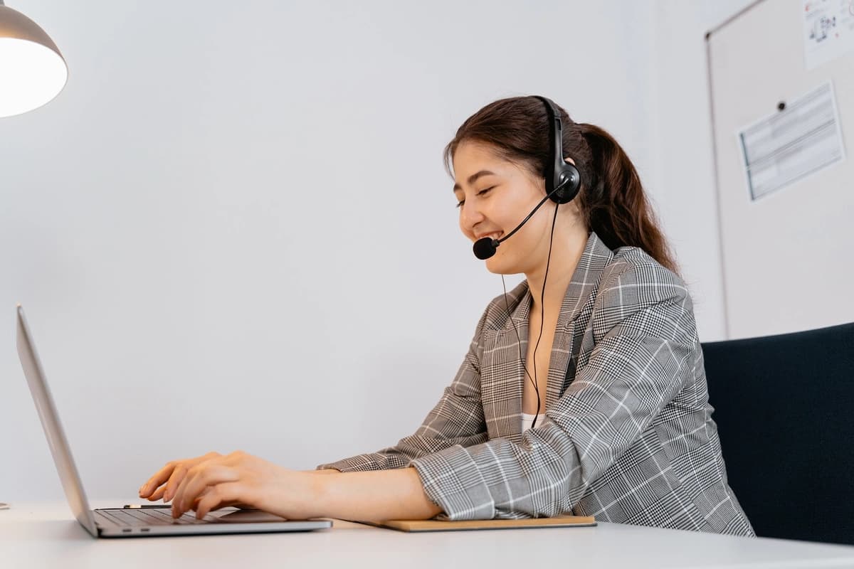 Woman on the phone with a customer at her desk, indicating the advantages of telemarketing.
